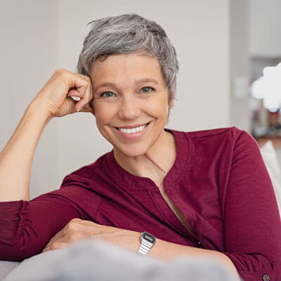 Older woman with short gray hair leaning on couch